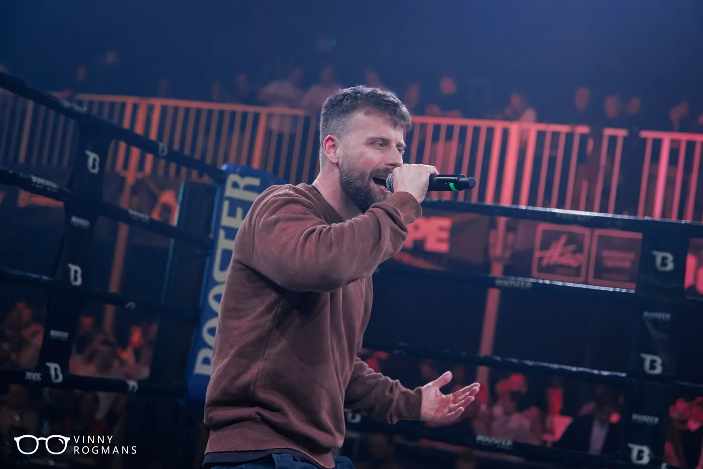 Presentator kondigt met de micro in de hand de volgende kamp aan